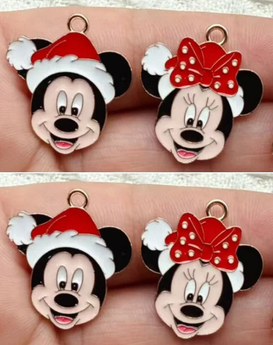 Two pairs of Disney character charms featuring Mickey Mouse in a red Santa hat and Minnie Mouse with a red polka-dot bow, shown on a person's fingers.