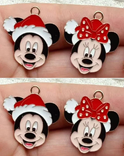 Two pairs of Disney character charms featuring Mickey Mouse in a red Santa hat and Minnie Mouse with a red polka-dot bow, shown on a person's fingers.