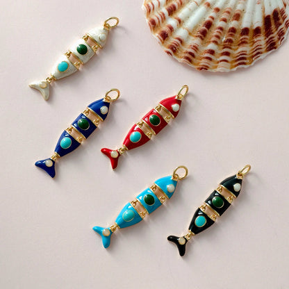 Colorful fish-shaped charms with gold accents on a light pink background