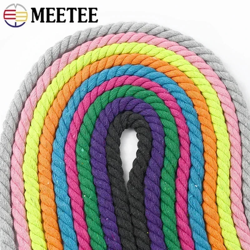 A coiled bundle of thick twisted rope shown in multiple colors, including gray, pink, yellow, orange, blue, purple, green, and black, arranged in concentric arches on a white background. 
