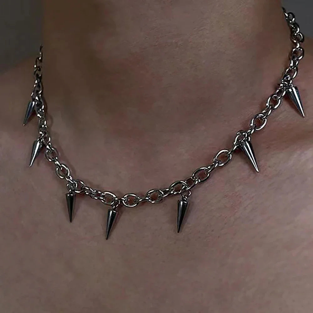 Silver chain necklace with spike pendants on a person's neck