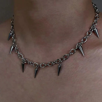 Silver chain necklace with spike pendants on a person's neck