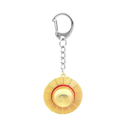 Gold circular keychain with red center on a white background