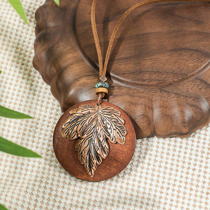 Wooden pendant with leaf design on a brown surface