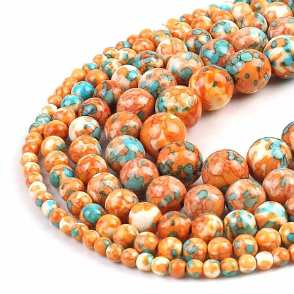 Coiled strands of round gemstone beads in orange, white, and turquoise blue with marbled patterns, photographed on a white background.
