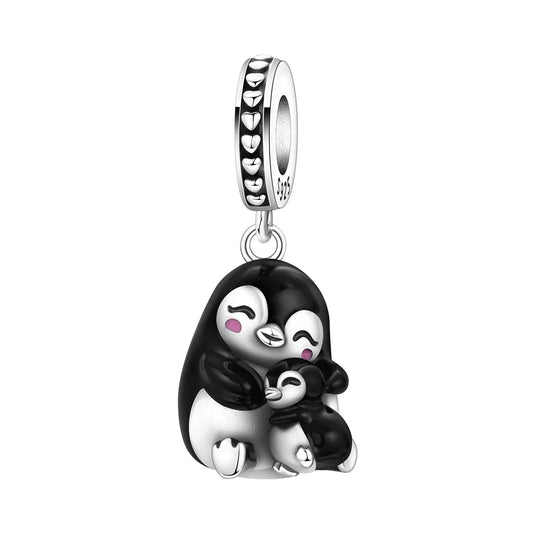 A silver charm featuring a penguin mother and baby hugging, with black and white enamel detailing and small pink blush accents on the cheeks.