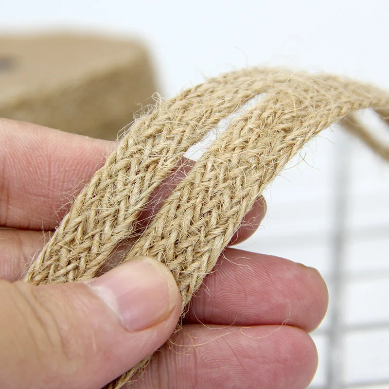 Close-up of a hand holding a piece of jute rope against a blurred background