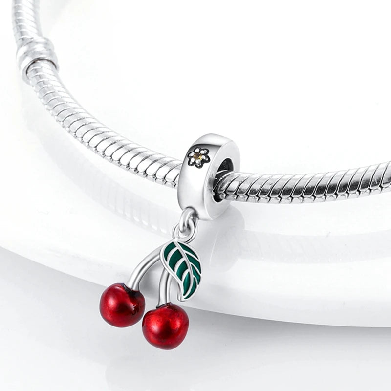 Silver bracelet with a cherry charm on a white background