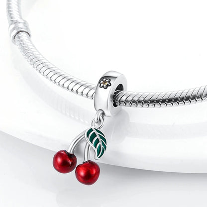 Silver bracelet with a cherry charm on a white background