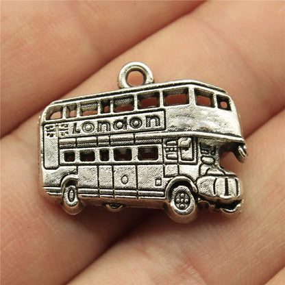 Silver London double-decker bus charm held between fingers