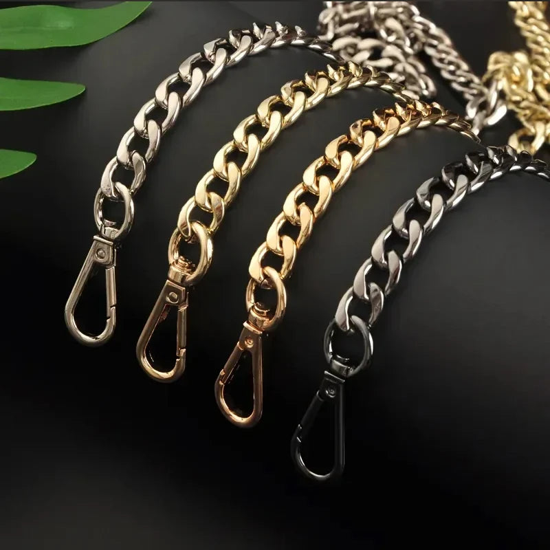 Four chain straps in silver, gold, and black on a dark background with green leaves.