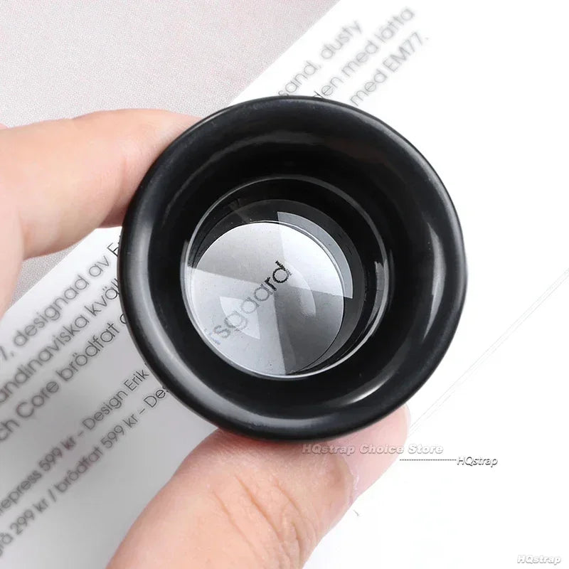 magnifying lens with 'Socord' branding held in a hand over printed text