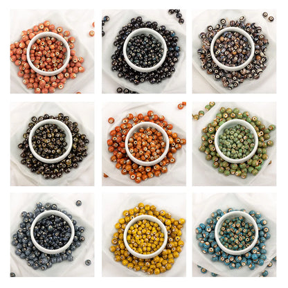 A 3x3 grid showing nine different colors of small round craft beads, each arranged in a white circular dish on a white background.