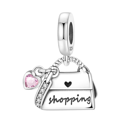 Silver charm shaped like a handbag with 'shopping' text and heart details on a white background