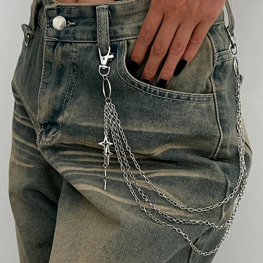 Denim pants with a chain accessory hanging from the pocket on a plain background