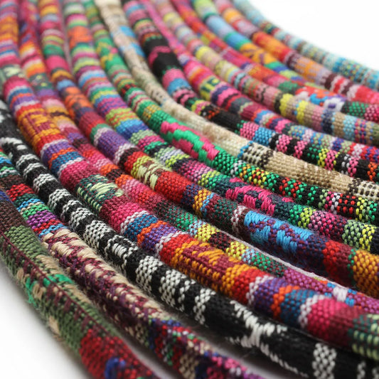 A close-up of multiple colorful woven cord or rope strands arranged in overlapping curves on a white background.