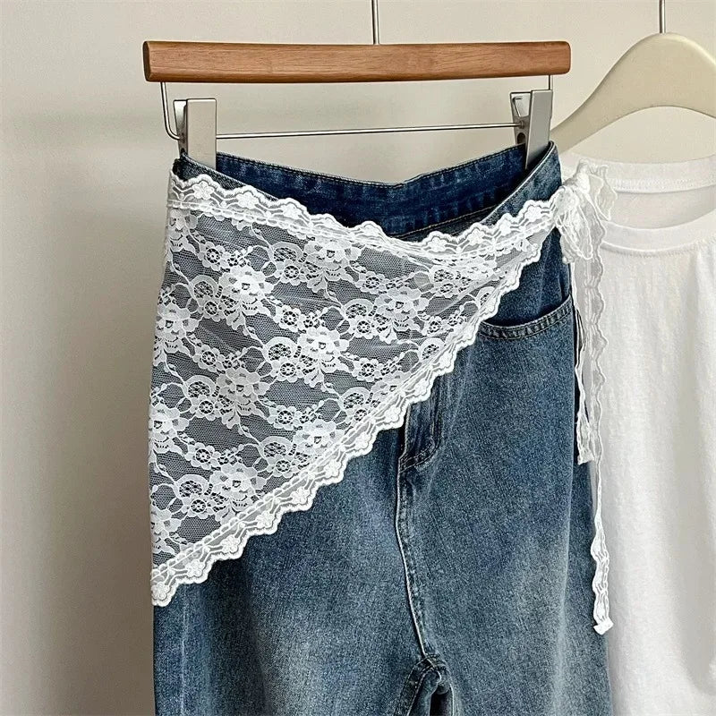 Blue jeans with white lace trim on a hanger against a neutral background