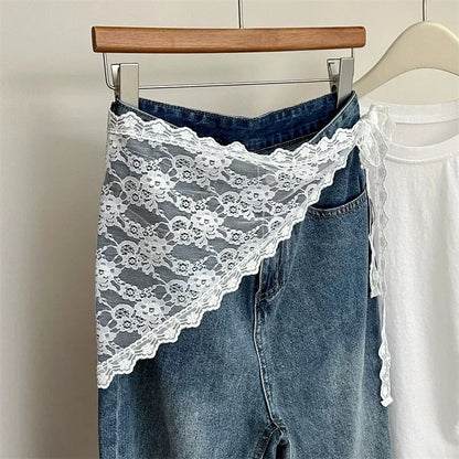 Blue jeans with white lace trim on a hanger against a neutral background