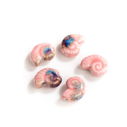 Five pink spiral-shaped beads with blue and purple marbled accents, arranged on a clean white background.