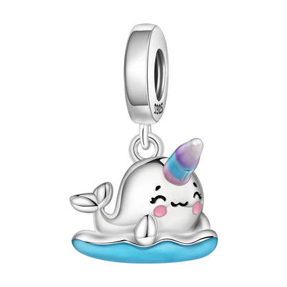 Silver narwhal charm with a unicorn horn on a white background