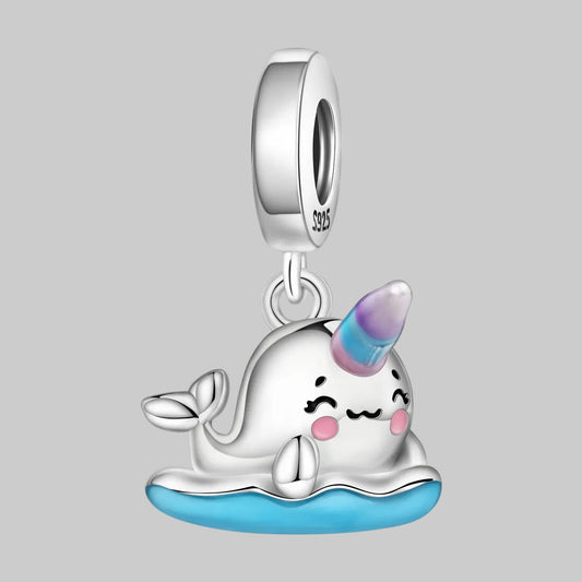 Silver narwhal charm with a unicorn horn on a white background
