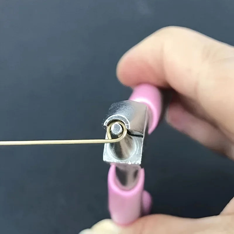 Pink jewelry making pliers with a clear cover held by a hand against a dark background