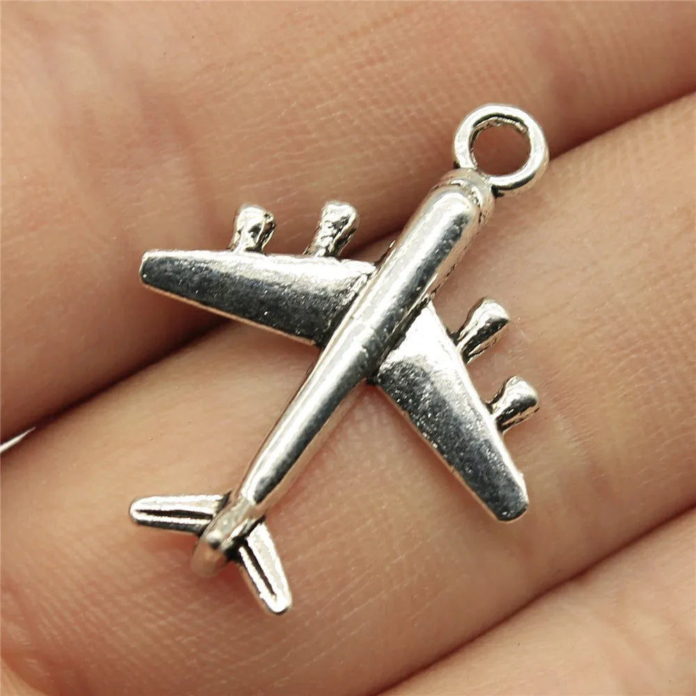 Travel charms for jewelry making featuring airplane, passport, suitcase and camera charms.