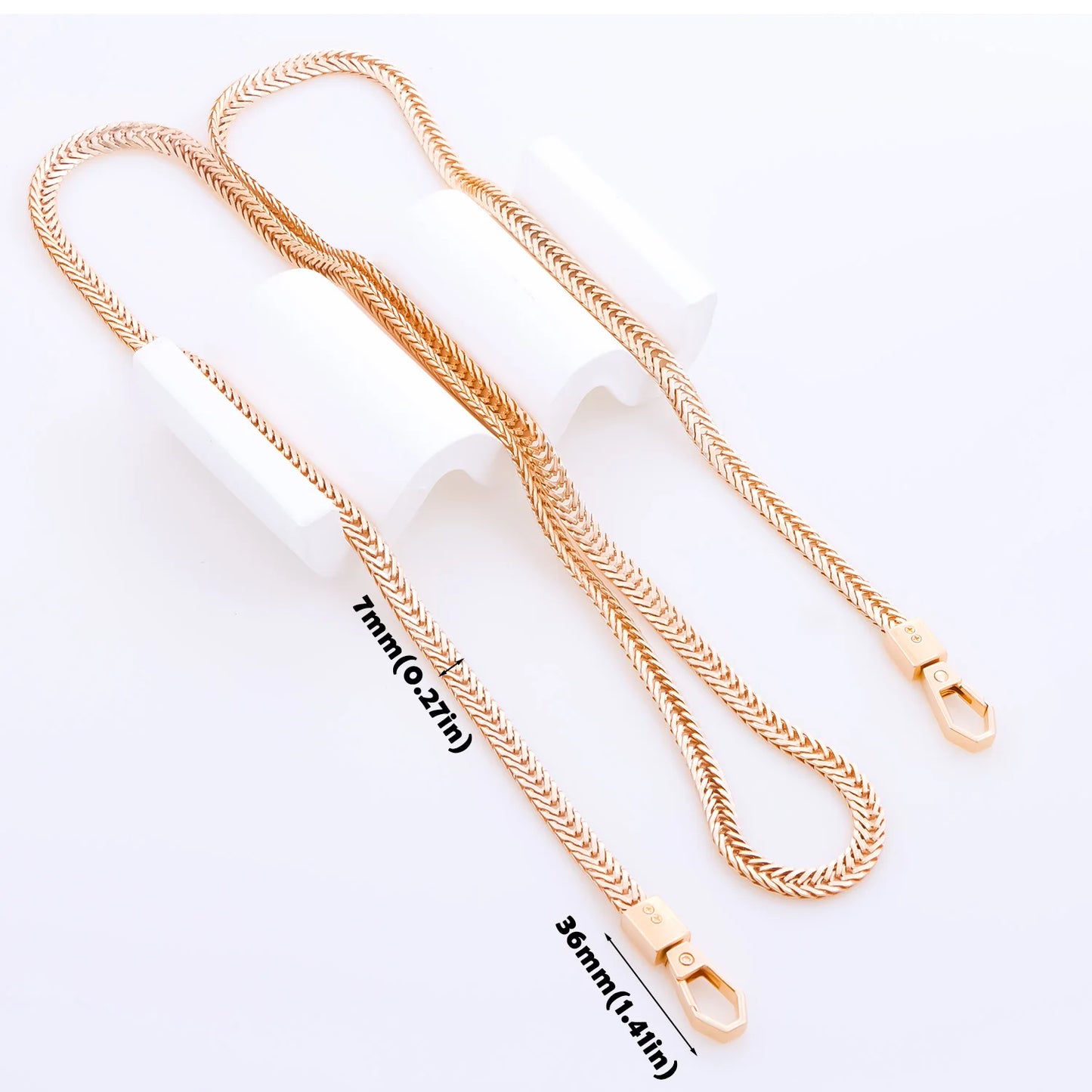 A rose gold rope chain necklace with a lobster clasp, displayed on a white background with two white cylindrical stands. Black text overlays indicate the chain's dimensions: 7mm (0.