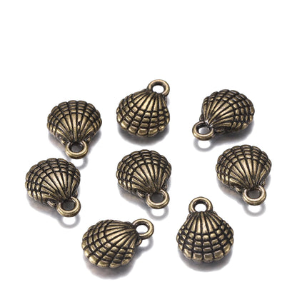 Nine antique bronze seashell-shaped jewelry charms with attached loops, arranged on a plain white background.