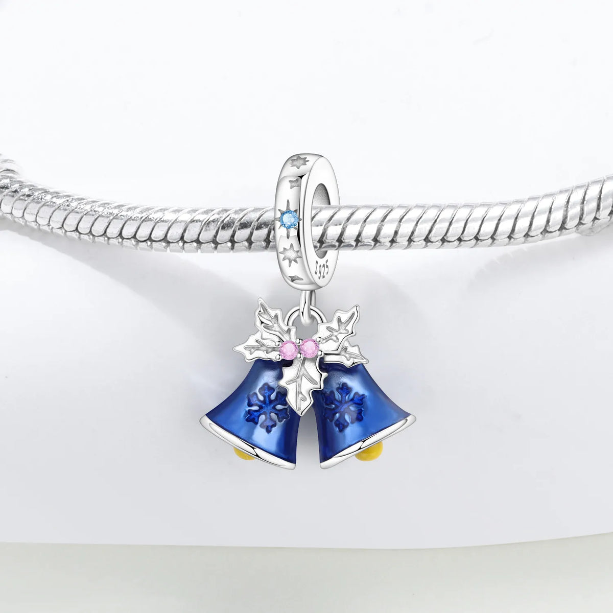 Silver Holiday charm with blue bell design on a white background