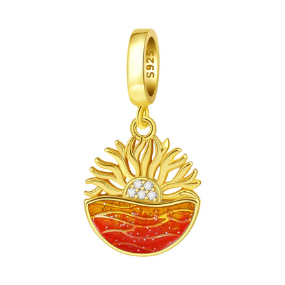 Gold pendant with red and orange ocean sunrise design on a white background