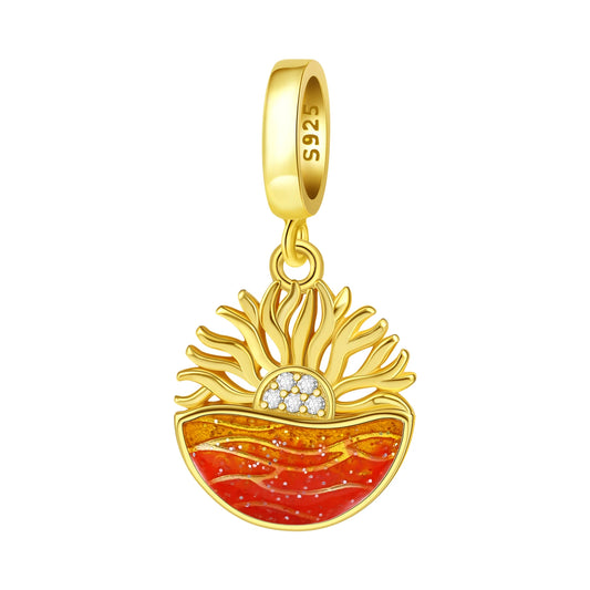Gold pendant with red and orange ocean sunrise design on a white background