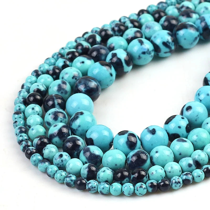 Multiple strands of polished round beads in turquoise and black marbled pattern, arranged in a curved coil on a white background.