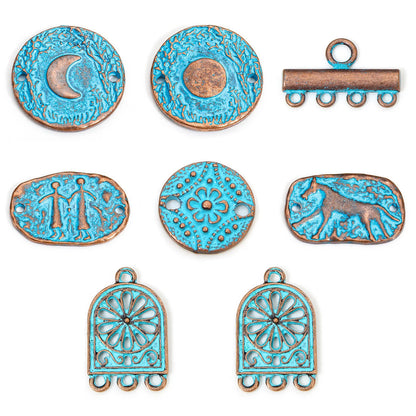 Seven decorative metal jewelry findings with distressed turquoise and bronze finishes, including crescent moon, sun, bar, floral medallion, and scroll motifs on a white background.