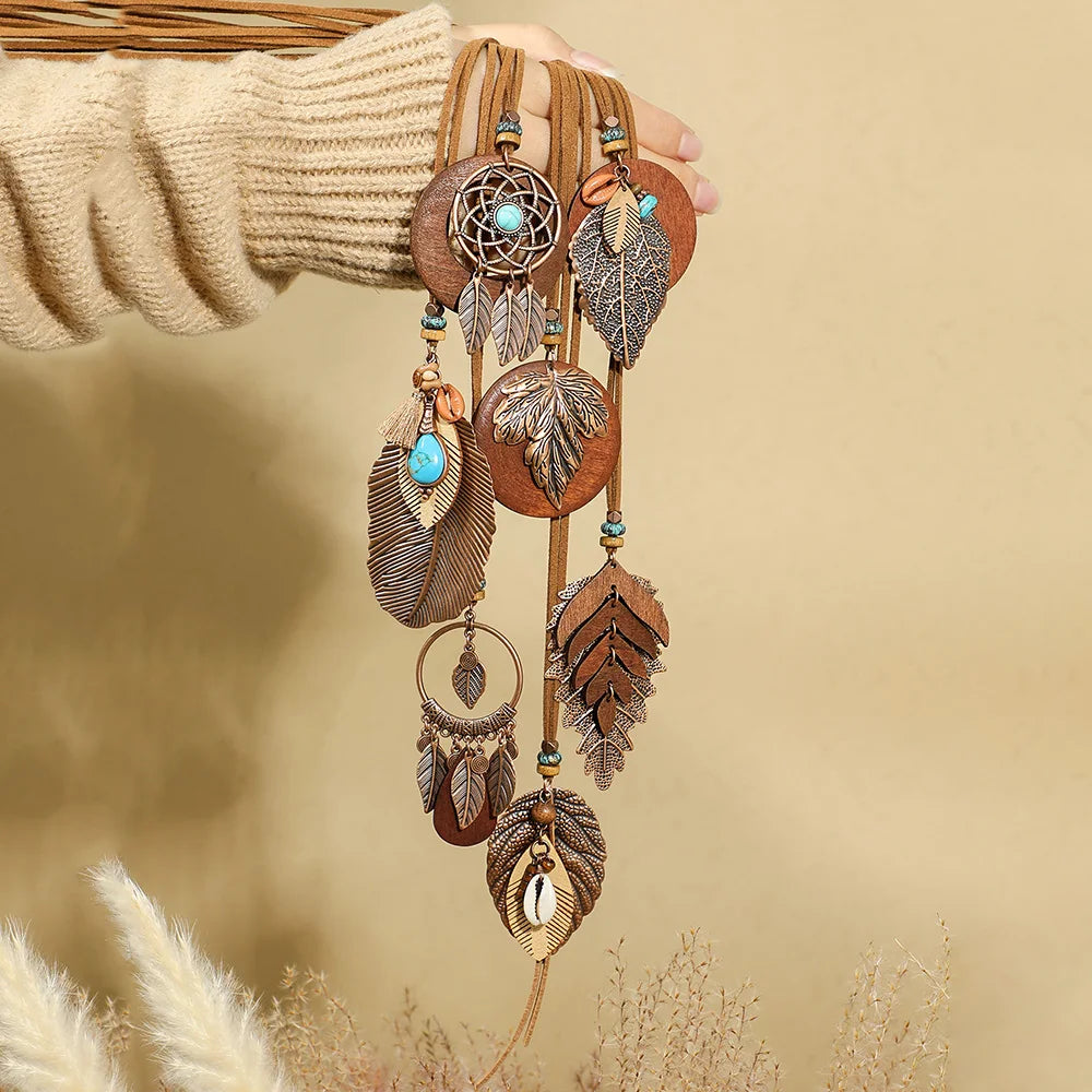 Decorative wall hanging with feathers and beads against a beige background