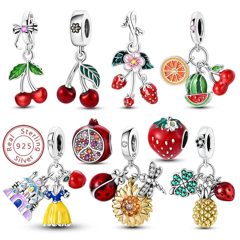 A set of 12 sterling silver charm beads with colorful enamel details, displayed on a clean white background. The charms include cherries, strawberries, watermelons, pomegranates, ladybugs, a sunflower, a dragonfly, a castle, a dress, and a pineapple, with one bead featuring a pink gemstone.