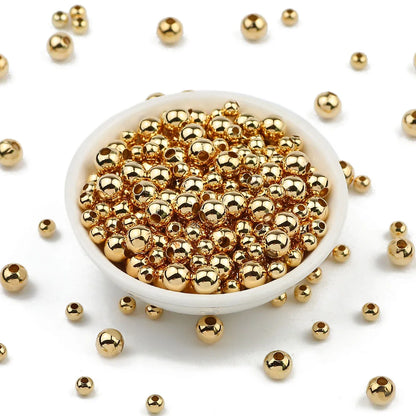 Gold beads in a white bowl with scattered beads on a white background