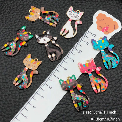 Colorful cat-shaped hair clips on a black textured background with a ruler for scale.
