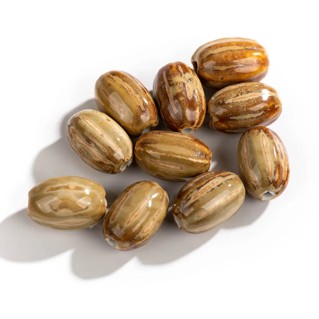 A cluster of glossy, oval-shaped brown and tan striped beads arranged on a plain white background.