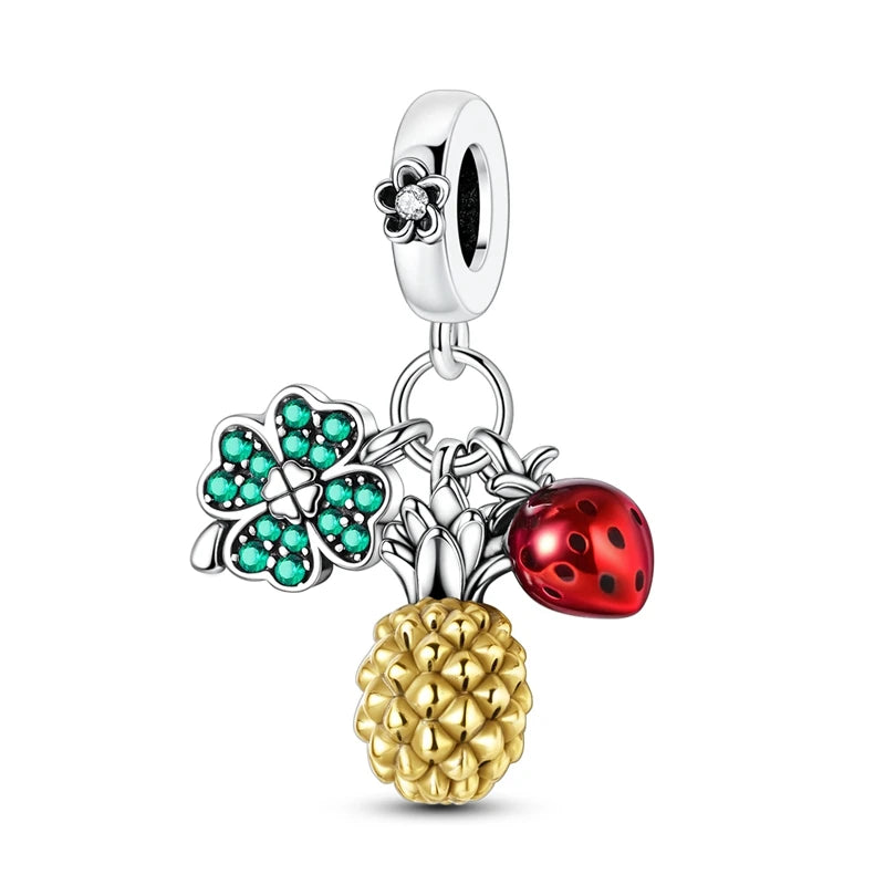 Multicolored charm with four-leaf clover, gold pineapple, and red ladybug on a white background