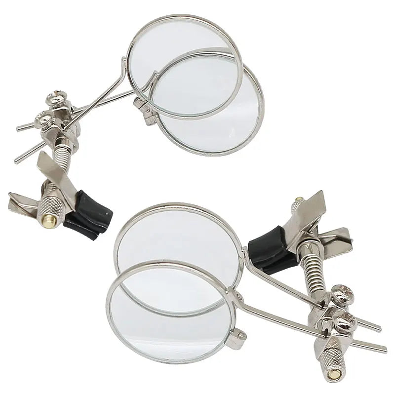 Set of magnifying glasses with adjustable clamps on a white background