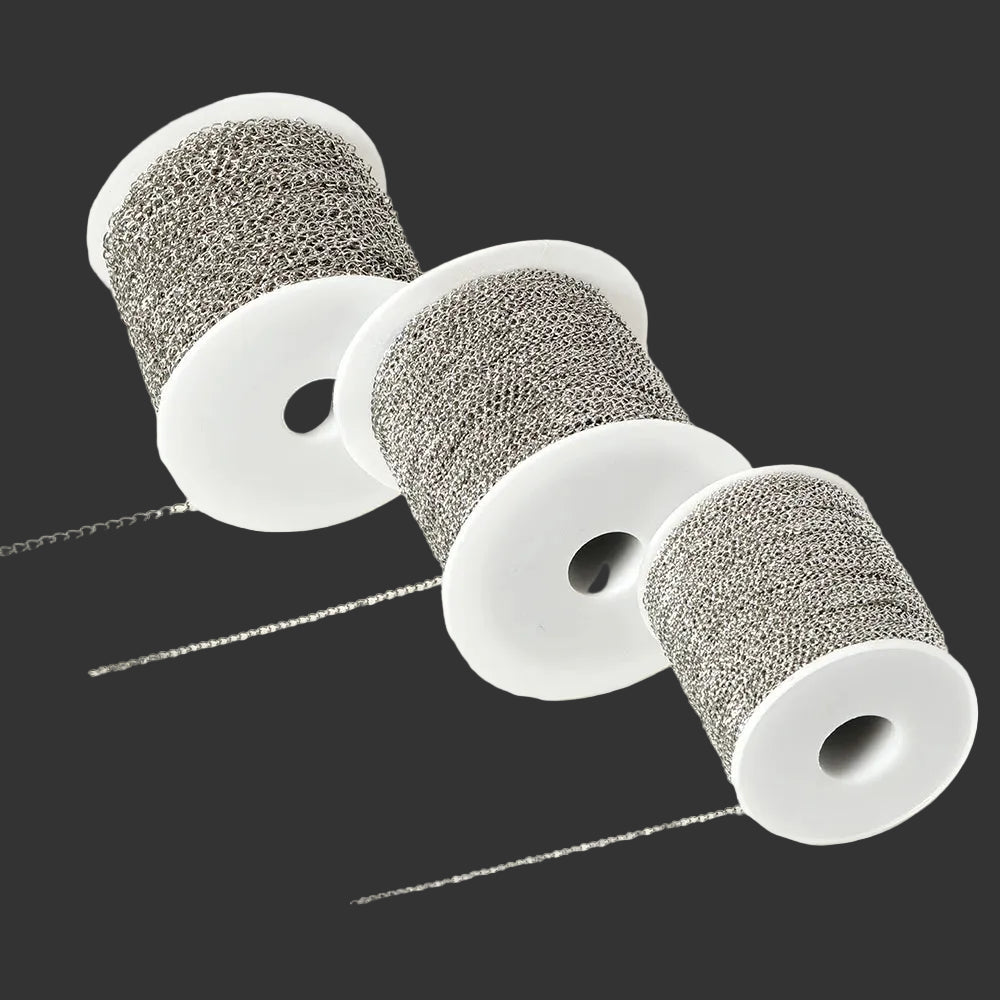 Three white plastic spools wound with silver-gray metallic chain material, with a few loose strands extending from the front, photographed on a clean white background.