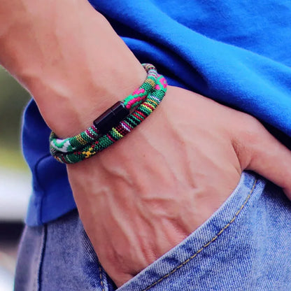 Colorful braided bracelet on a wrist with a blue shirt and jeans background