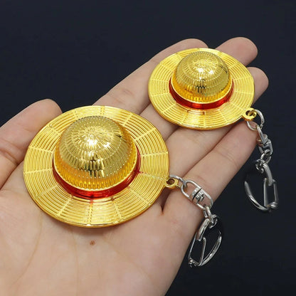 Gold-colored traditional hats with chains held in a hand against a dark background