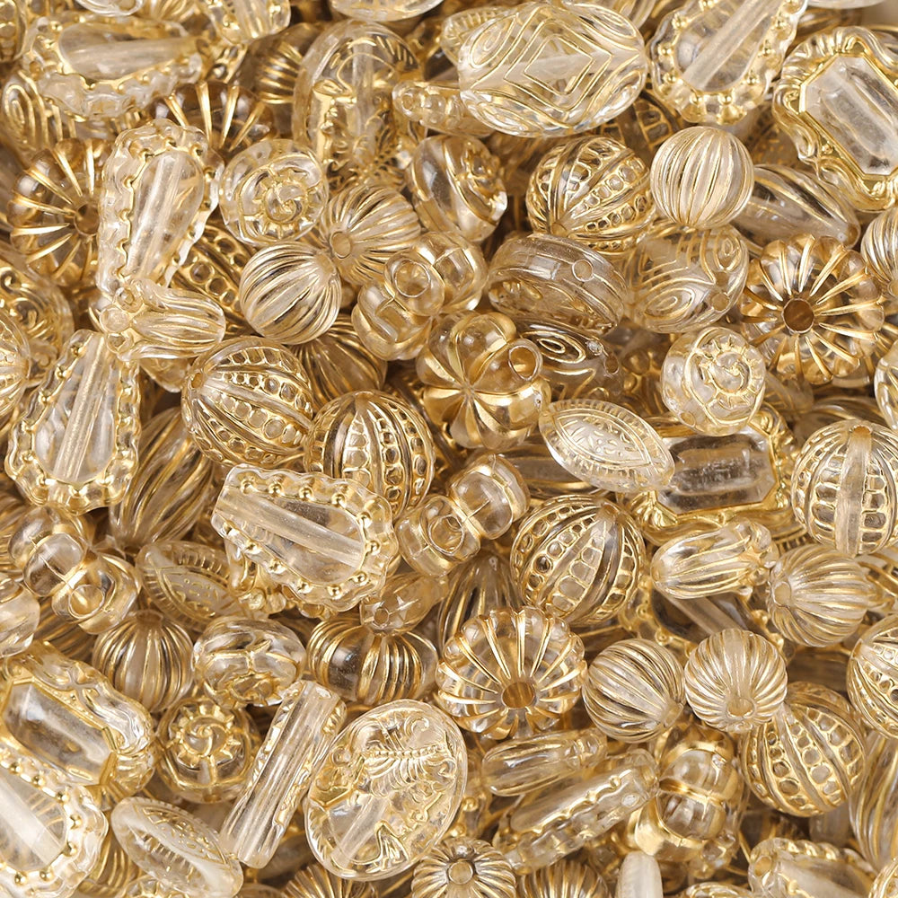 Close-up of gold and clear glass beads with intricate patterns.