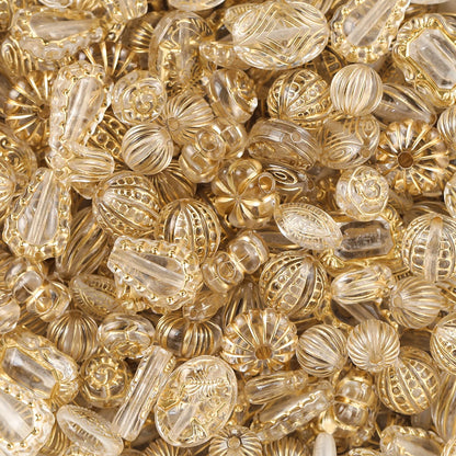 Close-up of gold and clear glass beads with intricate patterns.