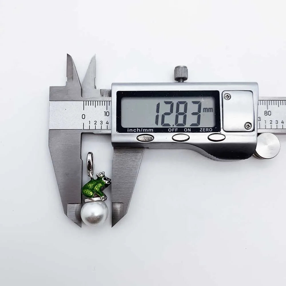 Digital caliper measuring a green stone pendant on a white background