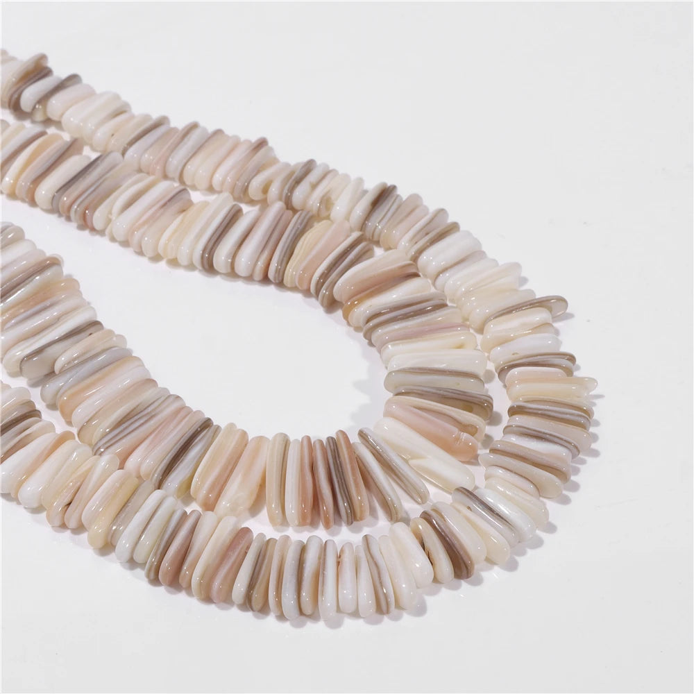 Multi-strand mother of pearl shell bead necklace featuring elongated, curved bar-shaped beads in natural beige, cream, and light brown tones, arranged on a plain white background.