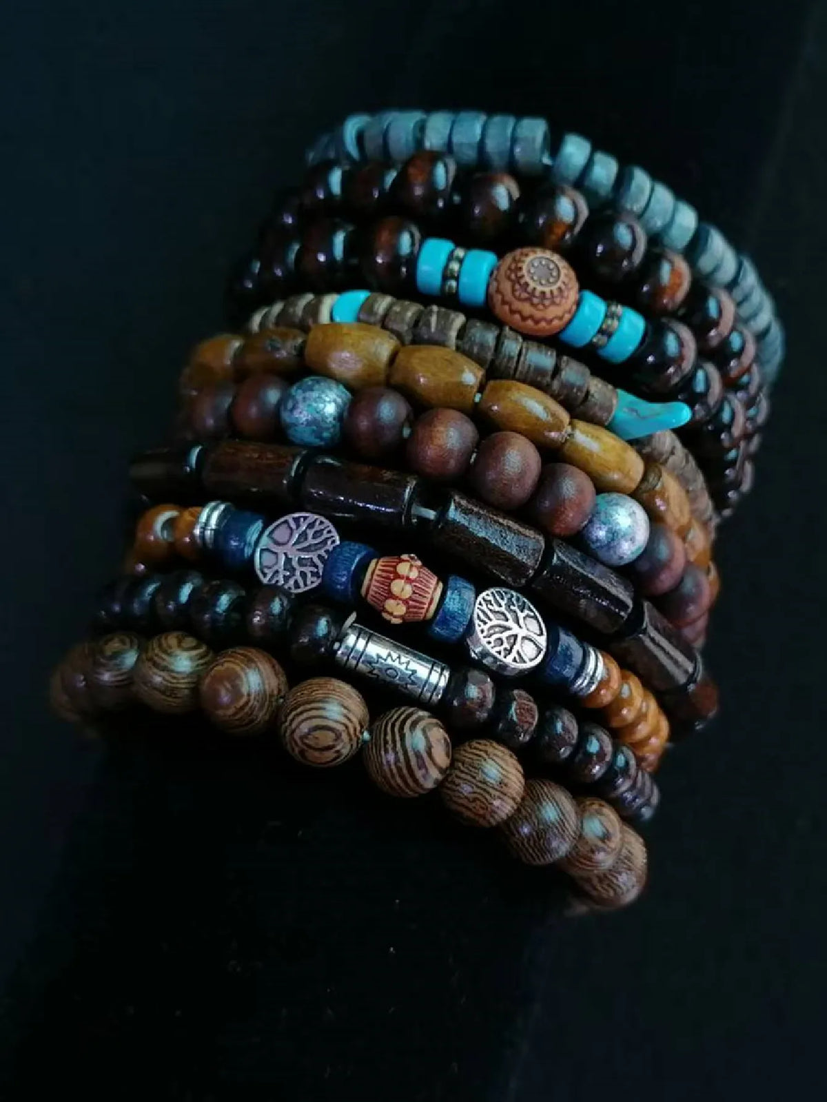 Stack of various beaded bracelets on a dark background