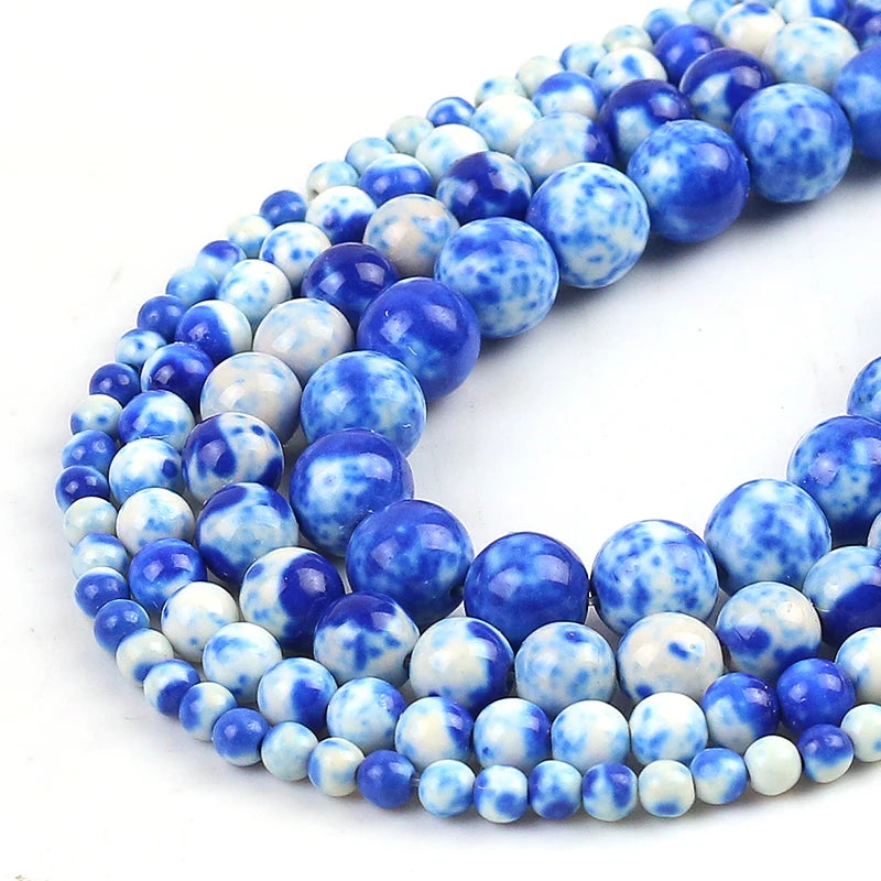 Blue and white marbled round beads arranged in multiple strands on a plain white background.